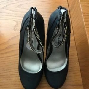 Black shoes with gold strap around ankle